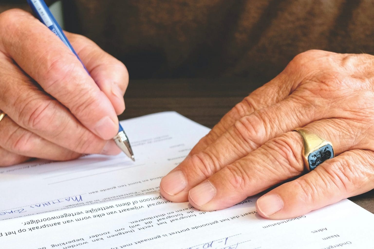 A person signing an estate document at a desk